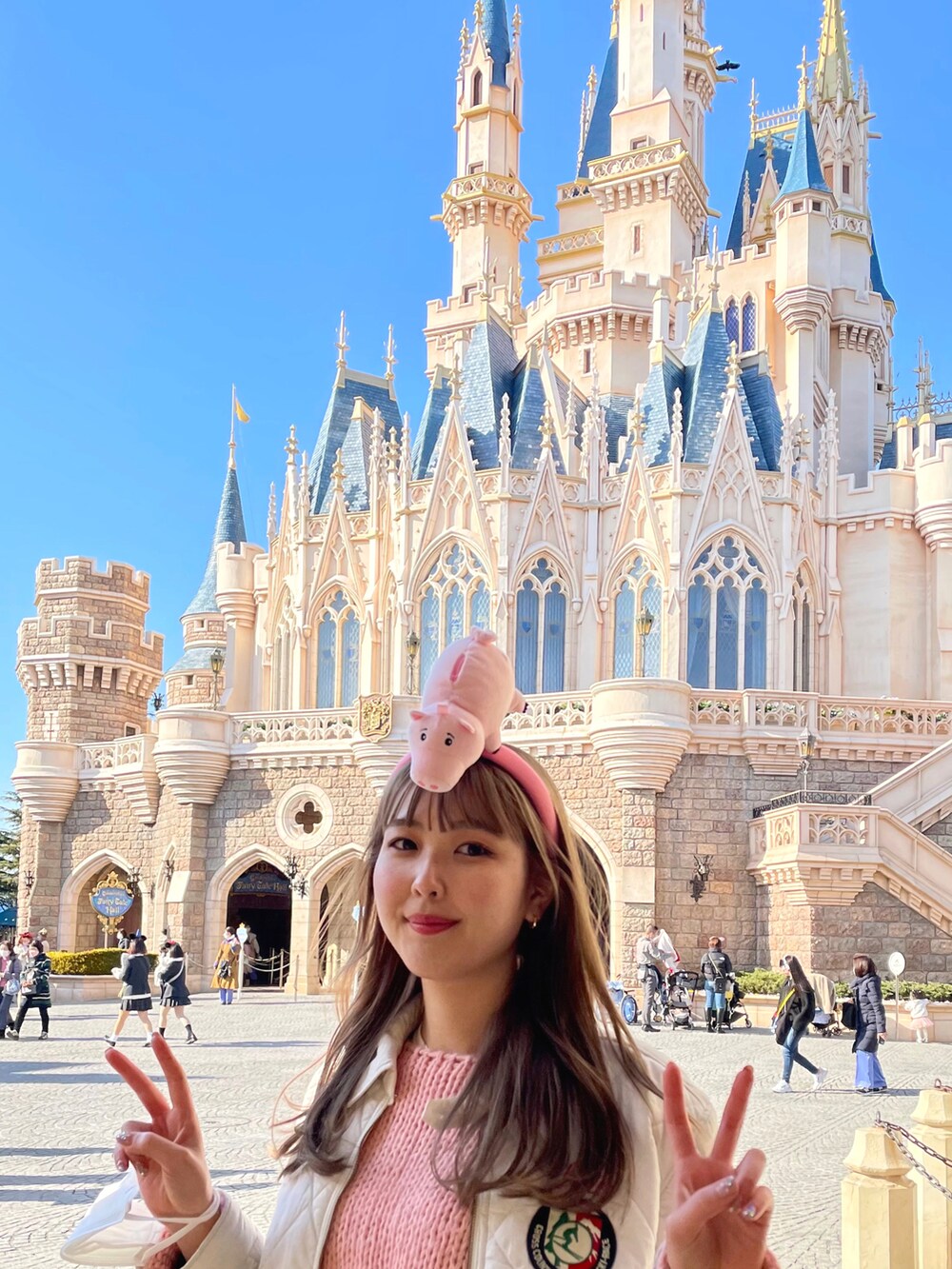 ピンク系のニット/セーター、ホワイト系のジャケット/アウター、パープル系のブーティを着用したレディースの冬コーディネートの2枚目の写真