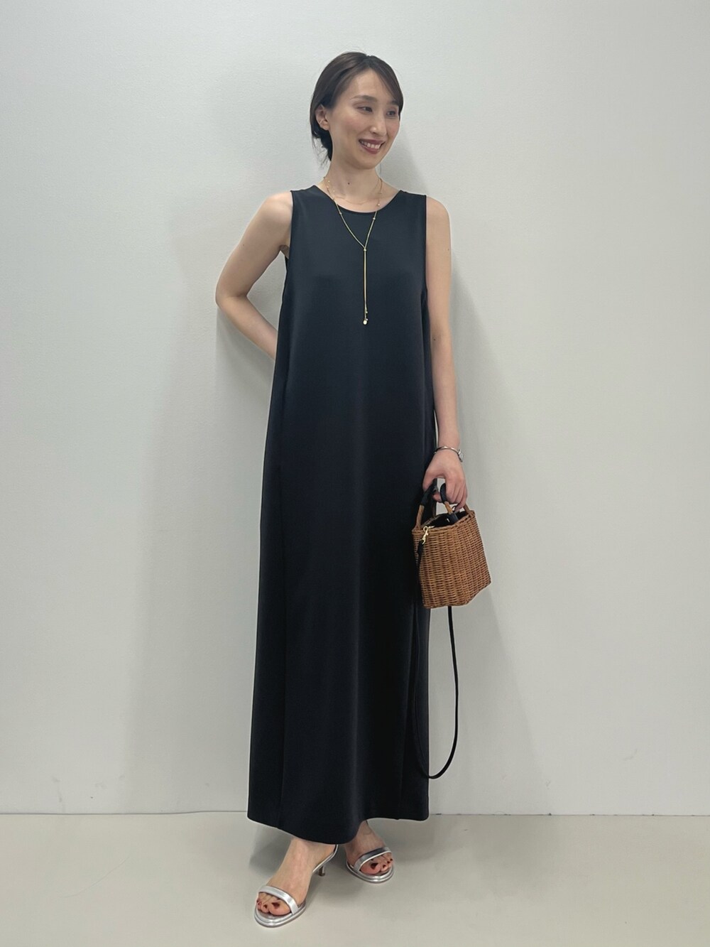 グレー系のワンピース、イエロー系のかごバッグ、シルバー系のサンダルを着用したレディースの春コーディネートの5枚目の写真