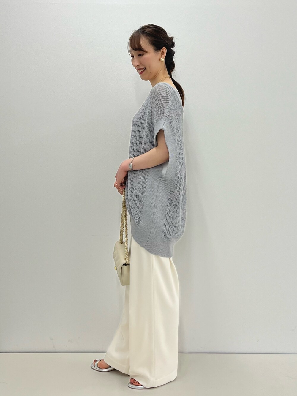 グレー系のベスト、ホワイト系のタンクトップ、ホワイト系のその他パンツを着用したレディースの春コーディネートの7枚目の写真