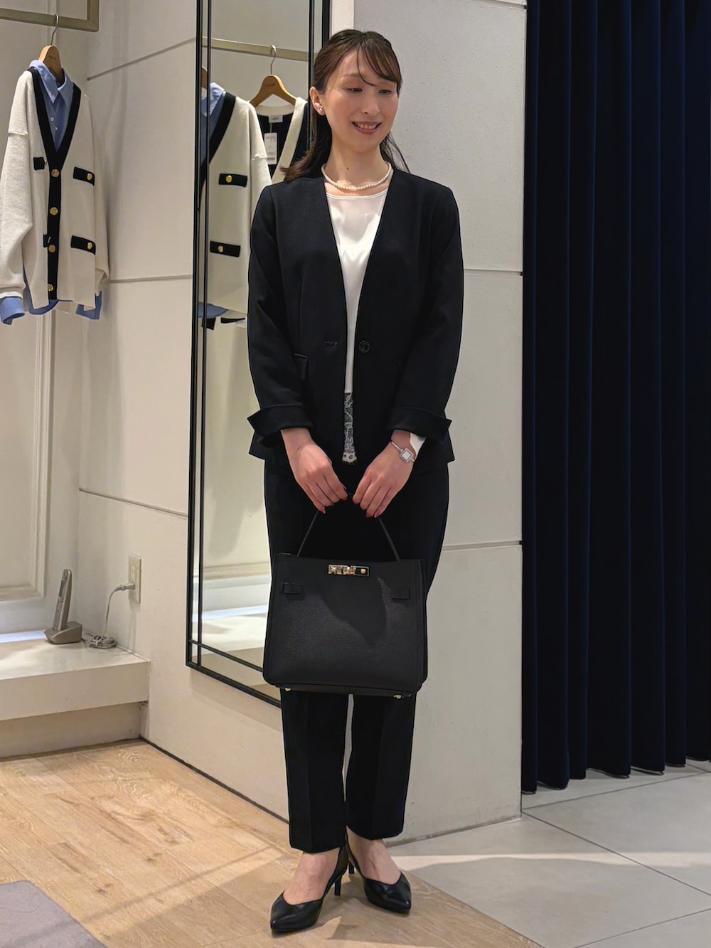 ホワイト系のシャツ/ブラウス、ブルー系のノーカラージャケット、ブラック系のショルダーバッグを着用したレディースの冬コーディネートの5枚目の写真