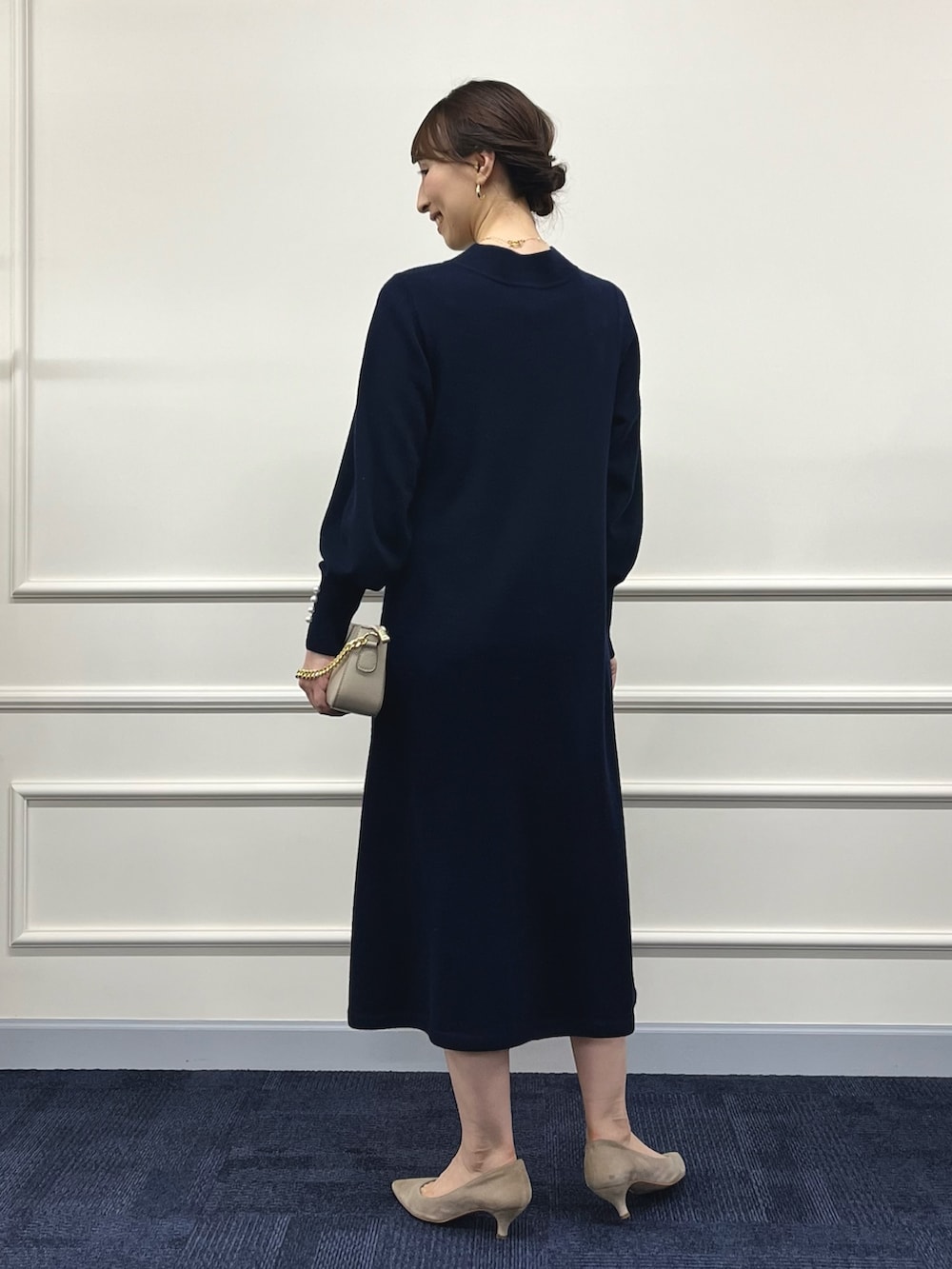 ベージュ系のショルダーバッグ、ブルー系のワンピース、ゴールド系のネックレスを着用したレディースの冬コーディネートの7枚目の写真