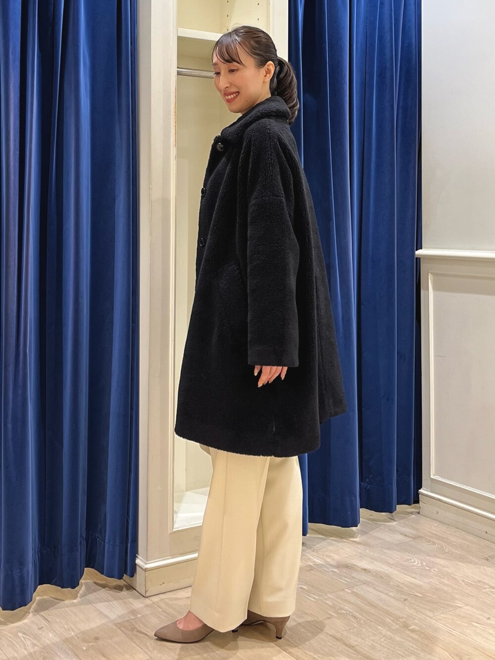 ブラック系のダッフルコート、ホワイト系のニット/セーター、イエロー系のその他パンツを着用したレディースの冬コーディネートの7枚目の写真