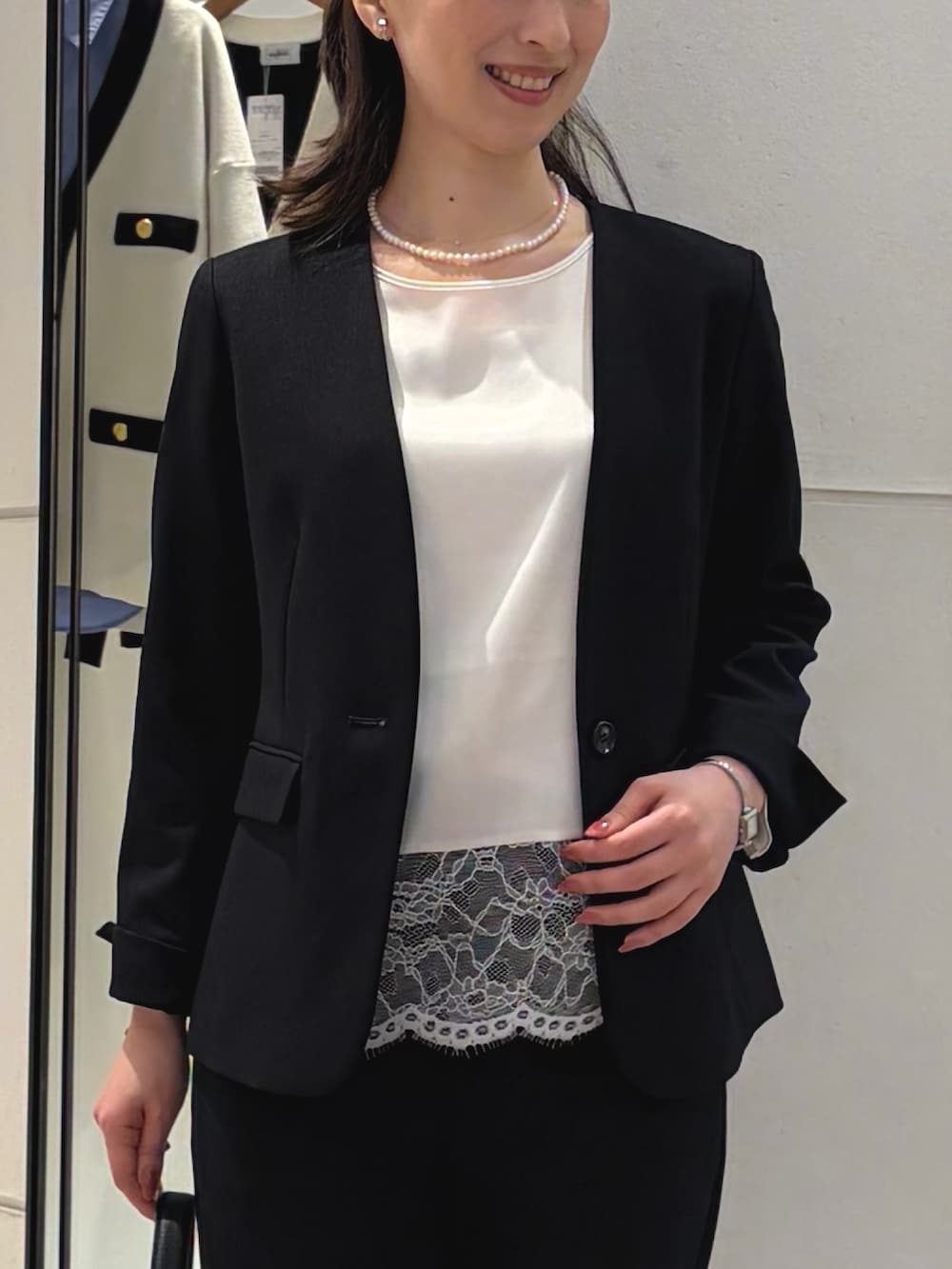 ホワイト系のシャツ/ブラウス、ブルー系のノーカラージャケット、ブラック系のショルダーバッグを着用したレディースの冬コーディネートの3枚目の写真