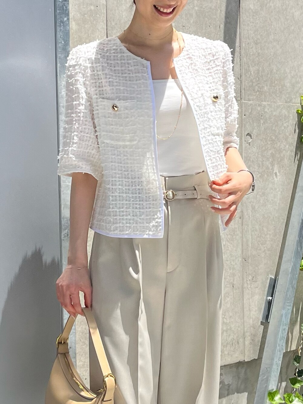 ホワイト系のノーカラージャケット、ベージュ系のその他パンツ、ベージュ系のショルダーバッグを着用したレディースの夏コーディネートの3枚目の写真