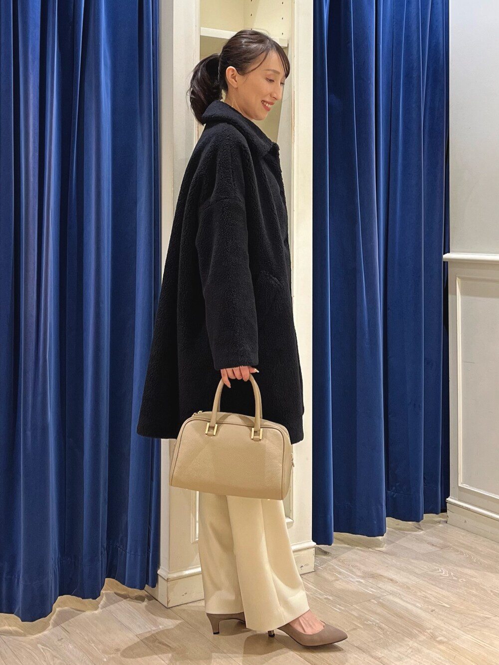 ブラック系のダッフルコート、ホワイト系のニット/セーター、イエロー系のその他パンツを着用したレディースの冬コーディネートの9枚目の写真