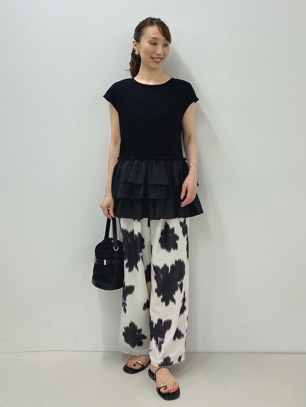 ブラック系のサンダル、ブラック系のTシャツ/カットソー、ホワイト系のその他パンツを着用したレディースの夏コーディネートの2枚目の写真