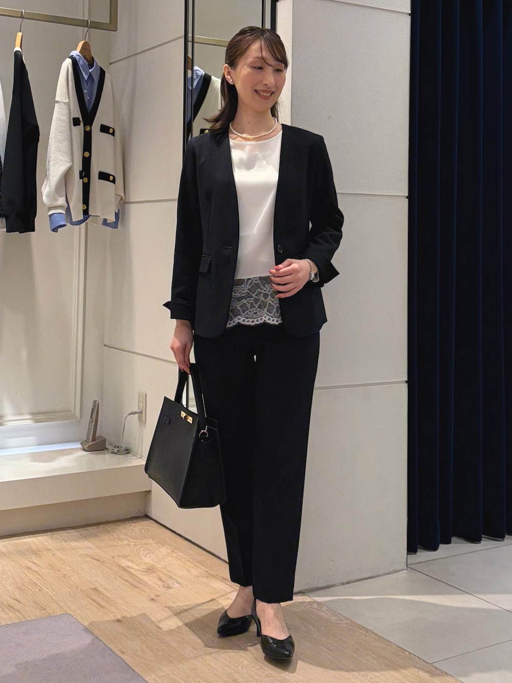 ホワイト系のシャツ/ブラウス、ブルー系のノーカラージャケット、ブラック系のショルダーバッグを着用したレディースの冬コーディネートの2枚目の写真