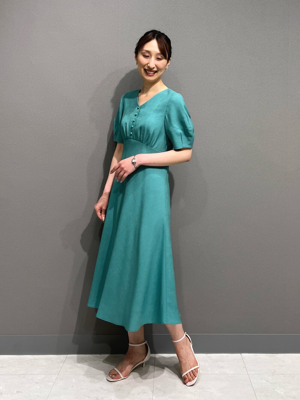 ブルー系のワンピース、ホワイト系のサンダル、ホワイト系のイヤリングを着用したレディースの春コーディネートの5枚目の写真