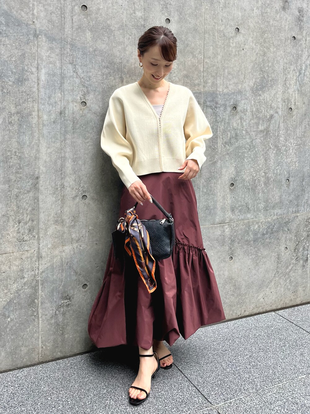 ホワイト系のカーディガン/ボレロ、レッド系のスカート、ブラック系のショルダーバッグを着用したレディースの夏コーディネートの2枚目の写真