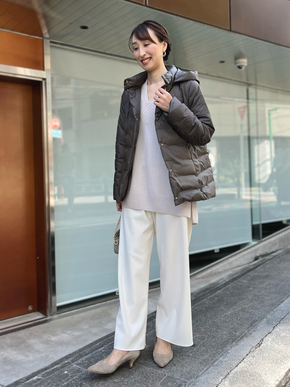 グリーン系のダウンジャケット/コート、ベージュ系のニット/セーター、ホワイト系のその他パンツを着用したレディースの秋コーディネートの2枚目の写真