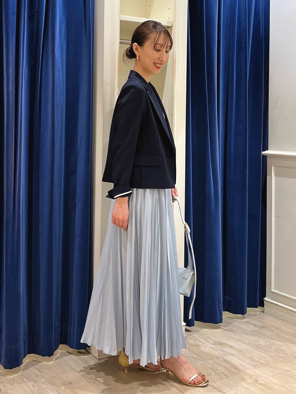 ブルー系のテーラードジャケット、ホワイト系のタンクトップ、ブルー系のスカートを着用したレディースの夏コーディネートの10枚目の写真