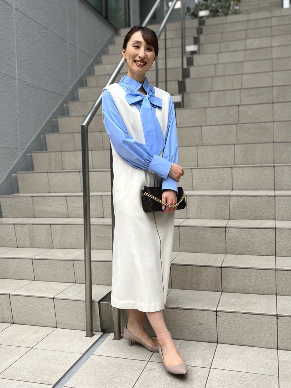 ブルー系のシャツ/ブラウス、ホワイト系のワンピース、ブルー系のショルダーバッグを着用したレディースの冬コーディネートの6枚目の写真