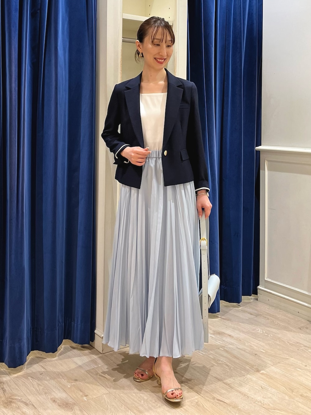 ブルー系のテーラードジャケット、ホワイト系のタンクトップ、ブルー系のスカートを着用したレディースの夏コーディネートの5枚目の写真