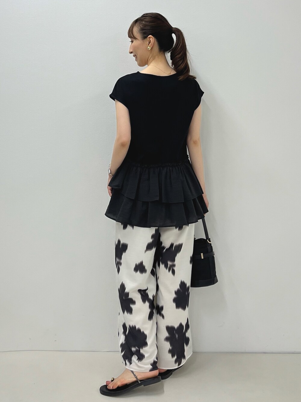 ブラック系のサンダル、ブラック系のTシャツ/カットソー、ホワイト系のその他パンツを着用したレディースの夏コーディネートの9枚目の写真