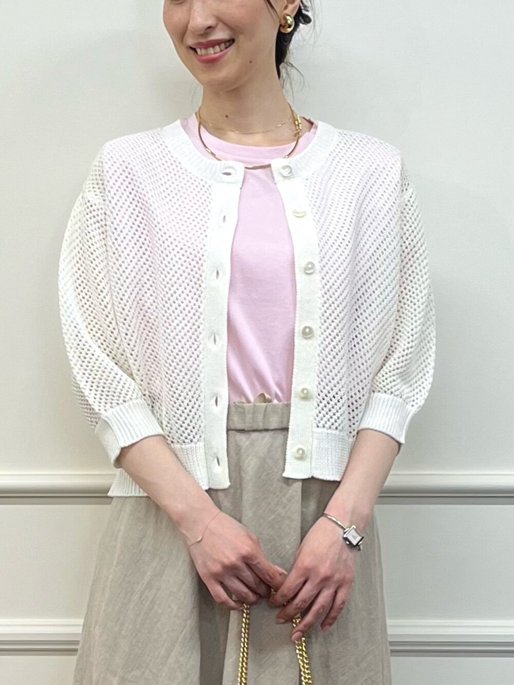 ホワイト系のカーディガン/ボレロ、ピンク系のTシャツ/カットソー、ベージュ系のスカートを着用したレディースの夏コーディネートの5枚目の写真