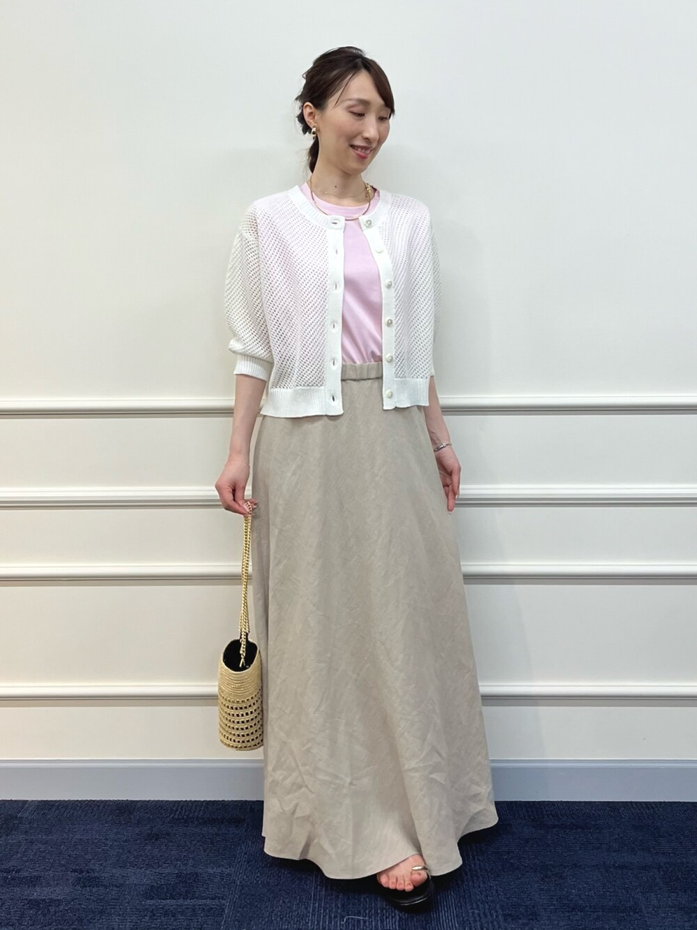 ホワイト系のカーディガン/ボレロ、ピンク系のTシャツ/カットソー、ベージュ系のスカートを着用したレディースの夏コーディネートの7枚目の写真