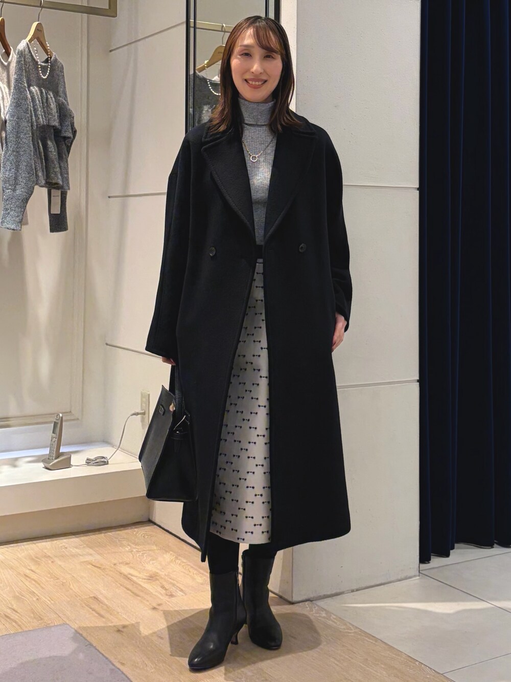 グレー系のその他トップス、ブラック系のその他アウター、ベージュ系のスカートを着用したレディースの冬コーディネートの4枚目の写真