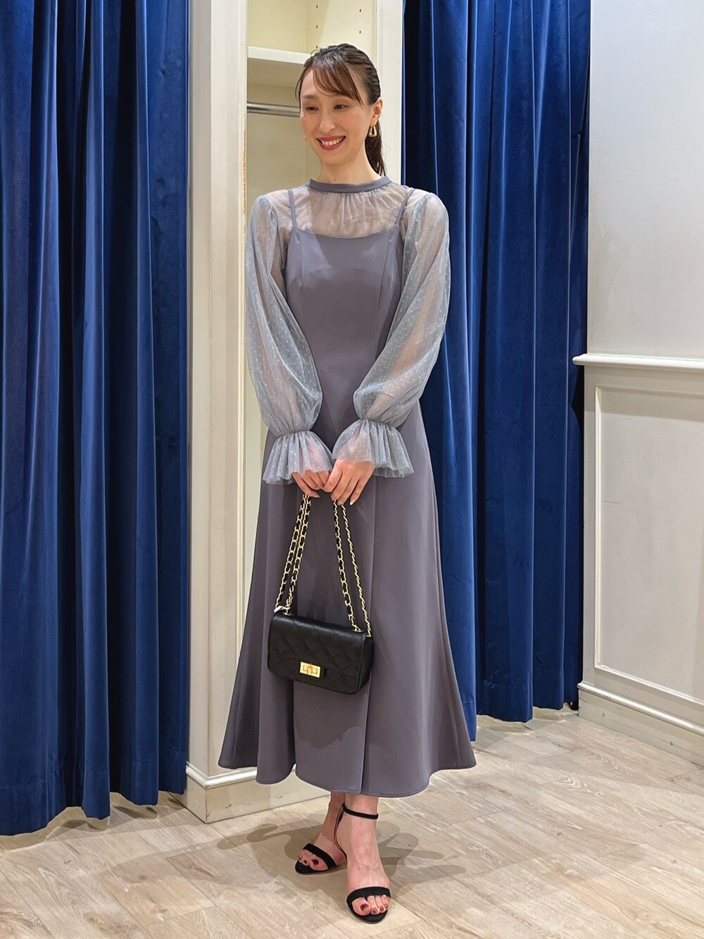 グレー系のワンピース、ブラック系のショルダーバッグを着用したレディースの夏コーディネートの8枚目の写真