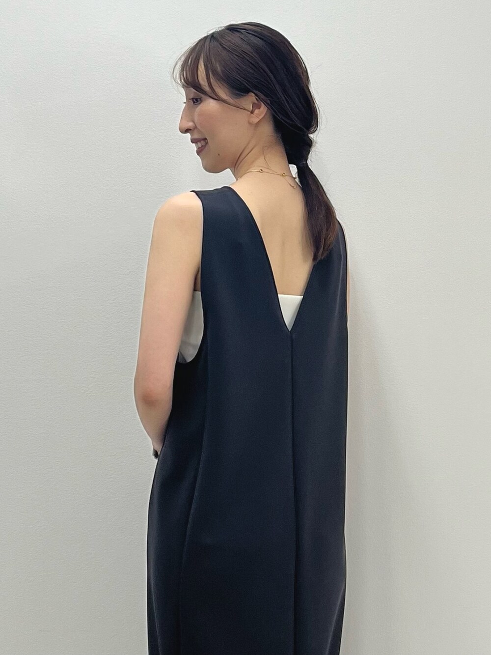 グレー系のワンピース、イエロー系のかごバッグ、シルバー系のサンダルを着用したレディースの春コーディネートの3枚目の写真