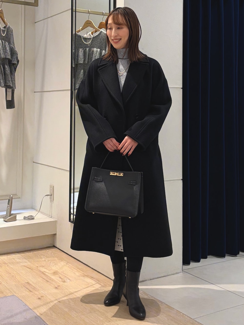 グレー系のその他トップス、ブラック系のその他アウター、ベージュ系のスカートを着用したレディースの冬コーディネートの3枚目の写真