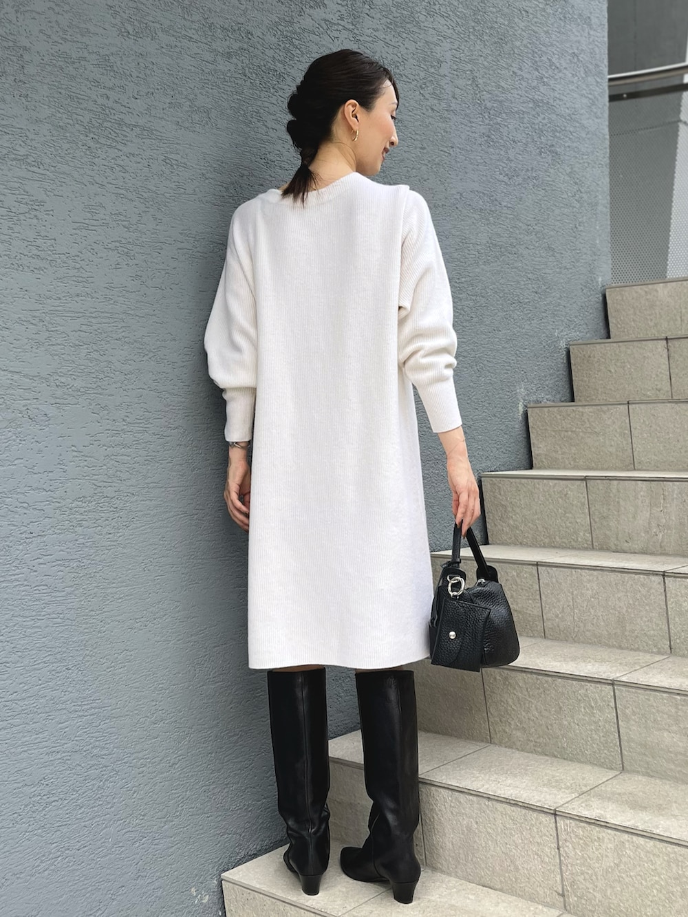 ホワイト系のニット/セーター、ブラック系のショルダーバッグを着用したレディースの秋コーディネートの4枚目の写真