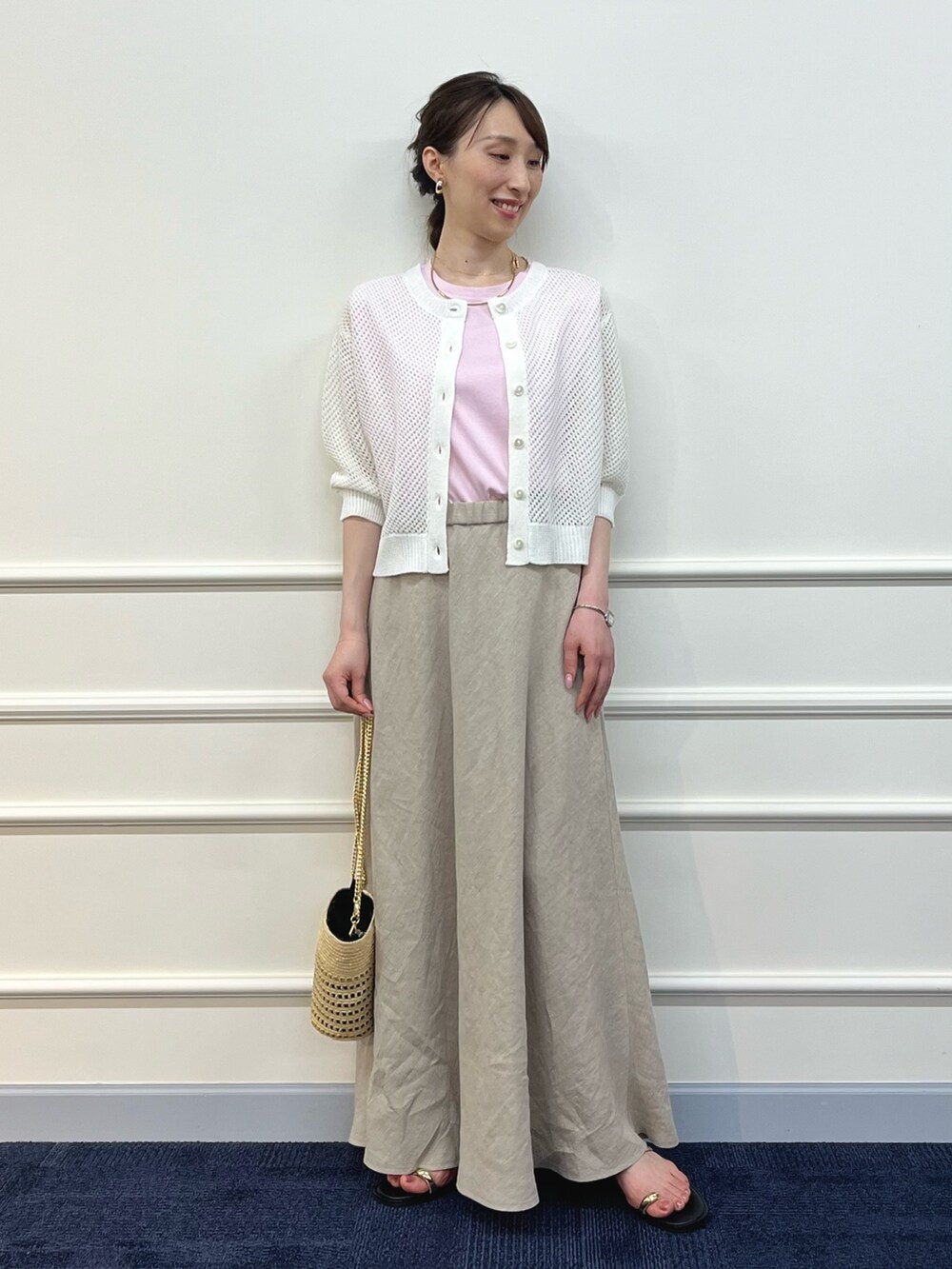 ホワイト系のカーディガン/ボレロ、ピンク系のTシャツ/カットソー、ベージュ系のスカートを着用したレディースの夏コーディネートの2枚目の写真