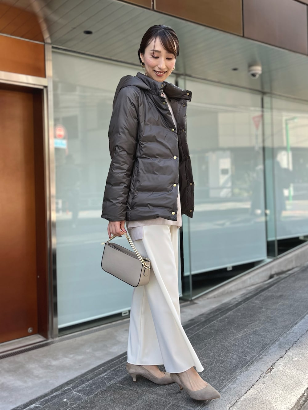 グリーン系のダウンジャケット/コート、ベージュ系のニット/セーター、ホワイト系のその他パンツを着用したレディースの秋コーディネートの4枚目の写真