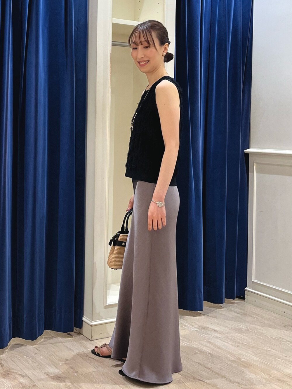 ブラック系のニット/セーター、グリーン系のスカート、ブラック系のかごバッグを着用したレディースの春コーディネートの8枚目の写真