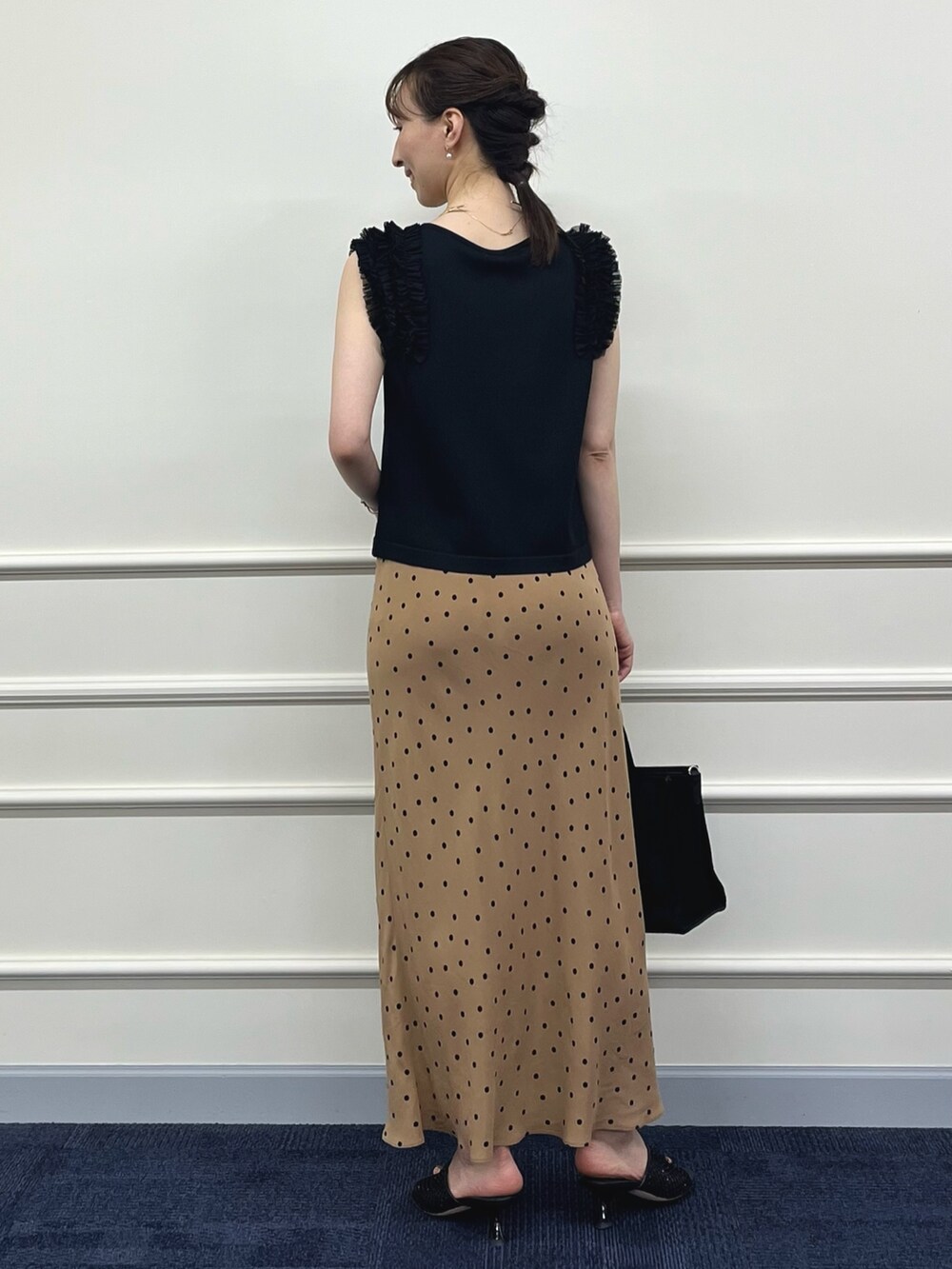 ブラック系のニット/セーター、ブラウン系のスカート、ブラック系のトートバッグを着用したレディースの夏コーディネートの10枚目の写真