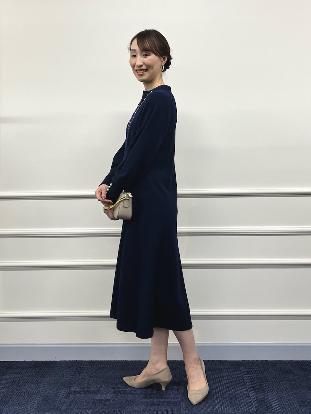 ベージュ系のショルダーバッグ、ブルー系のワンピース、ゴールド系のネックレスを着用したレディースの冬コーディネートの5枚目の写真