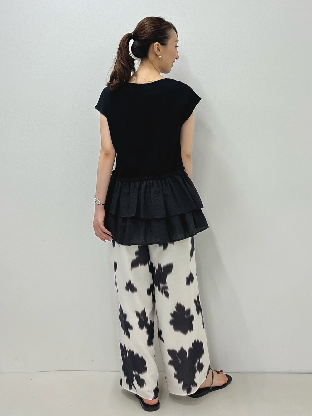 ブラック系のサンダル、ブラック系のTシャツ/カットソー、ホワイト系のその他パンツを着用したレディースの夏コーディネートの10枚目の写真