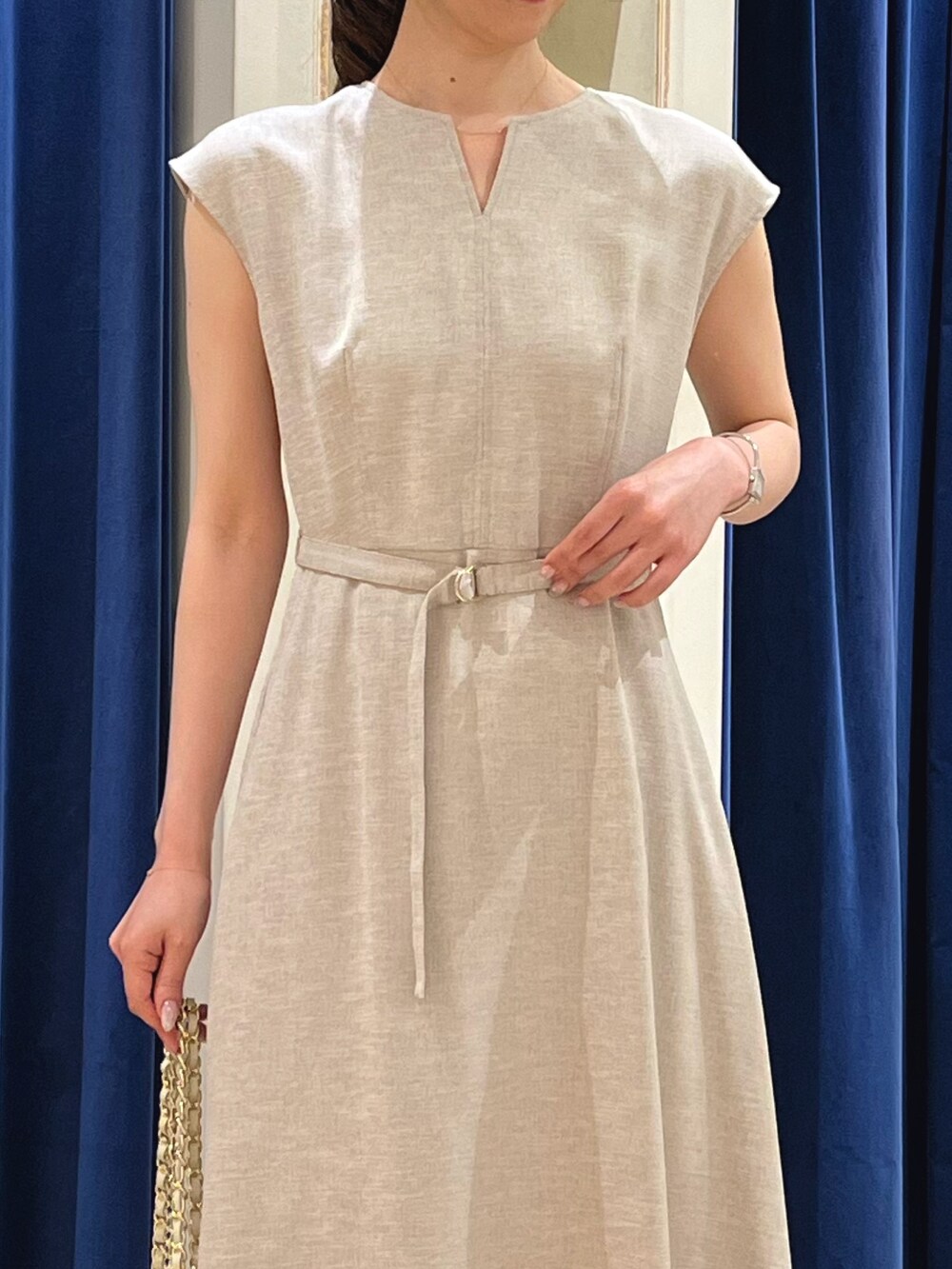 ベージュ系のワンピース、ホワイト系のショルダーバッグ、ゴールド系のサンダルを着用したレディースの夏コーディネートの6枚目の写真