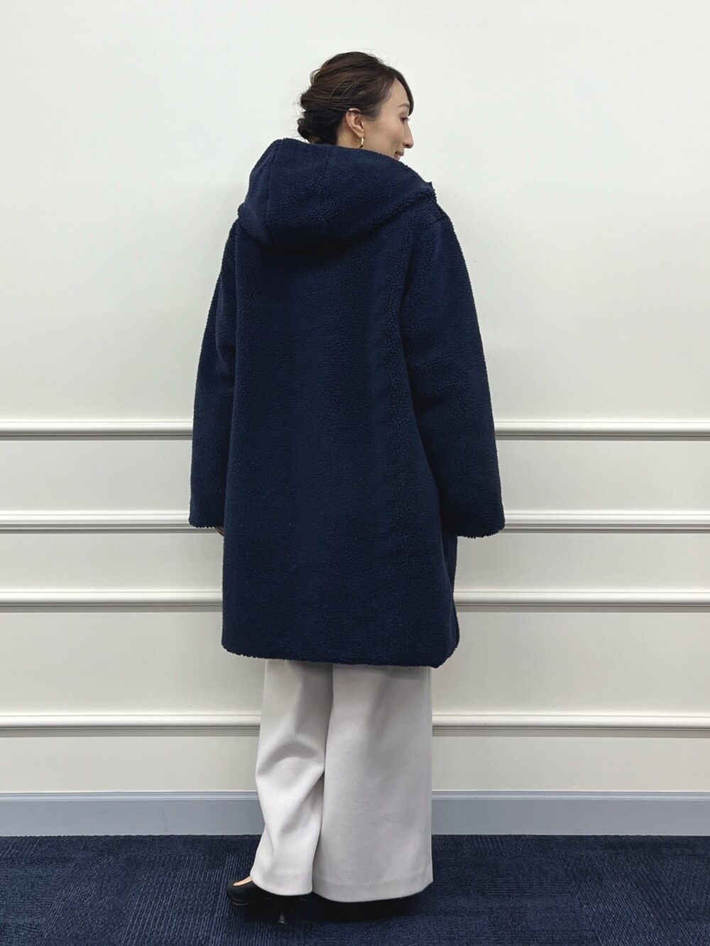 ブルー系のダウンジャケット/コート、ブラック系のニット/セーター、ベージュ系のその他パンツを着用したレディースの秋コーディネートの9枚目の写真