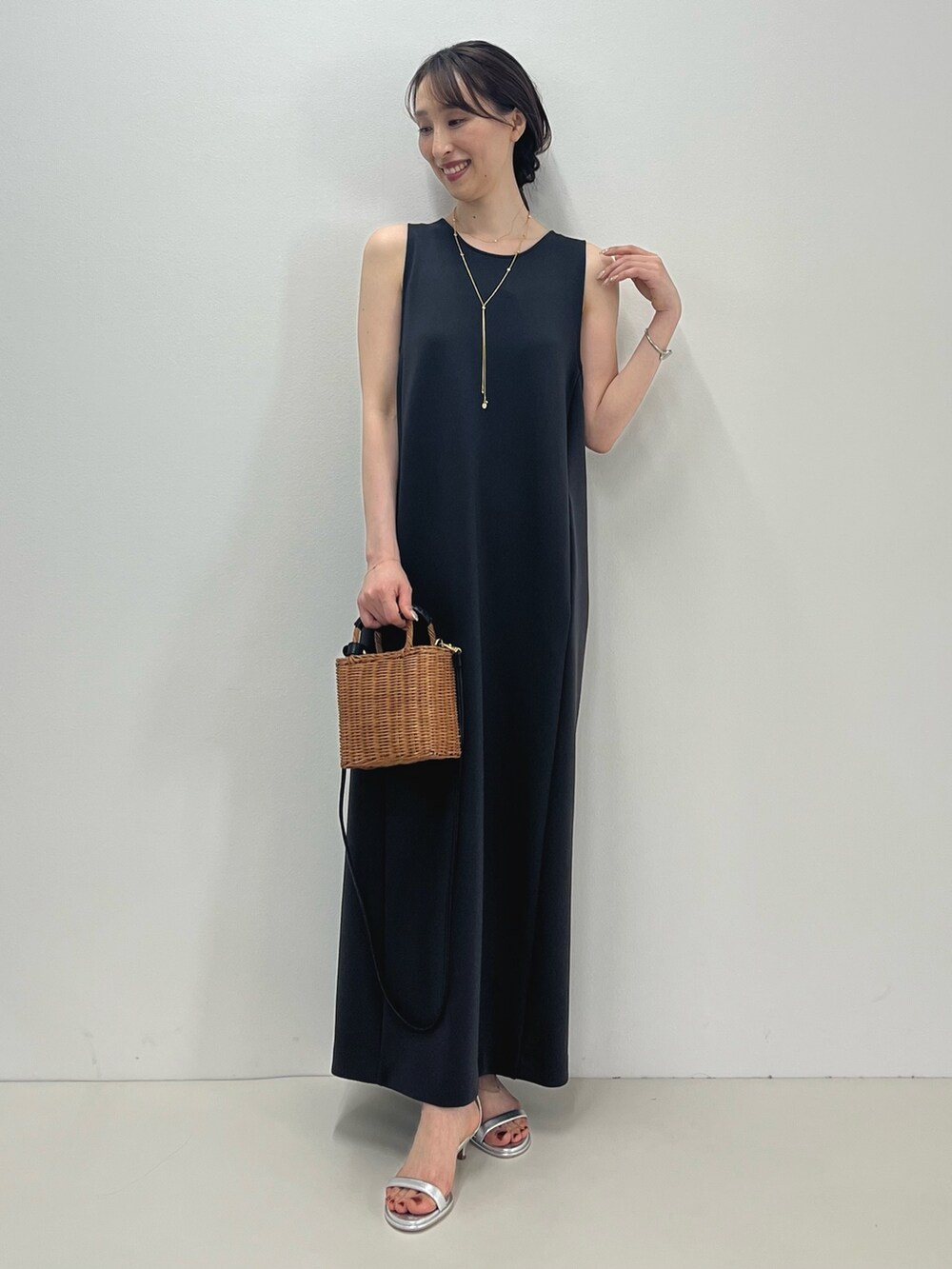 グレー系のワンピース、イエロー系のかごバッグ、シルバー系のサンダルを着用したレディースの春コーディネートの7枚目の写真