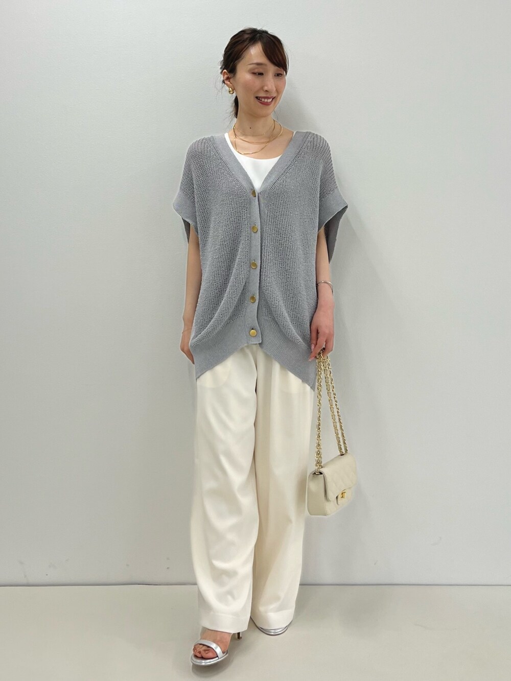 グレー系のベスト、ホワイト系のタンクトップ、ホワイト系のその他パンツを着用したレディースの春コーディネートの4枚目の写真