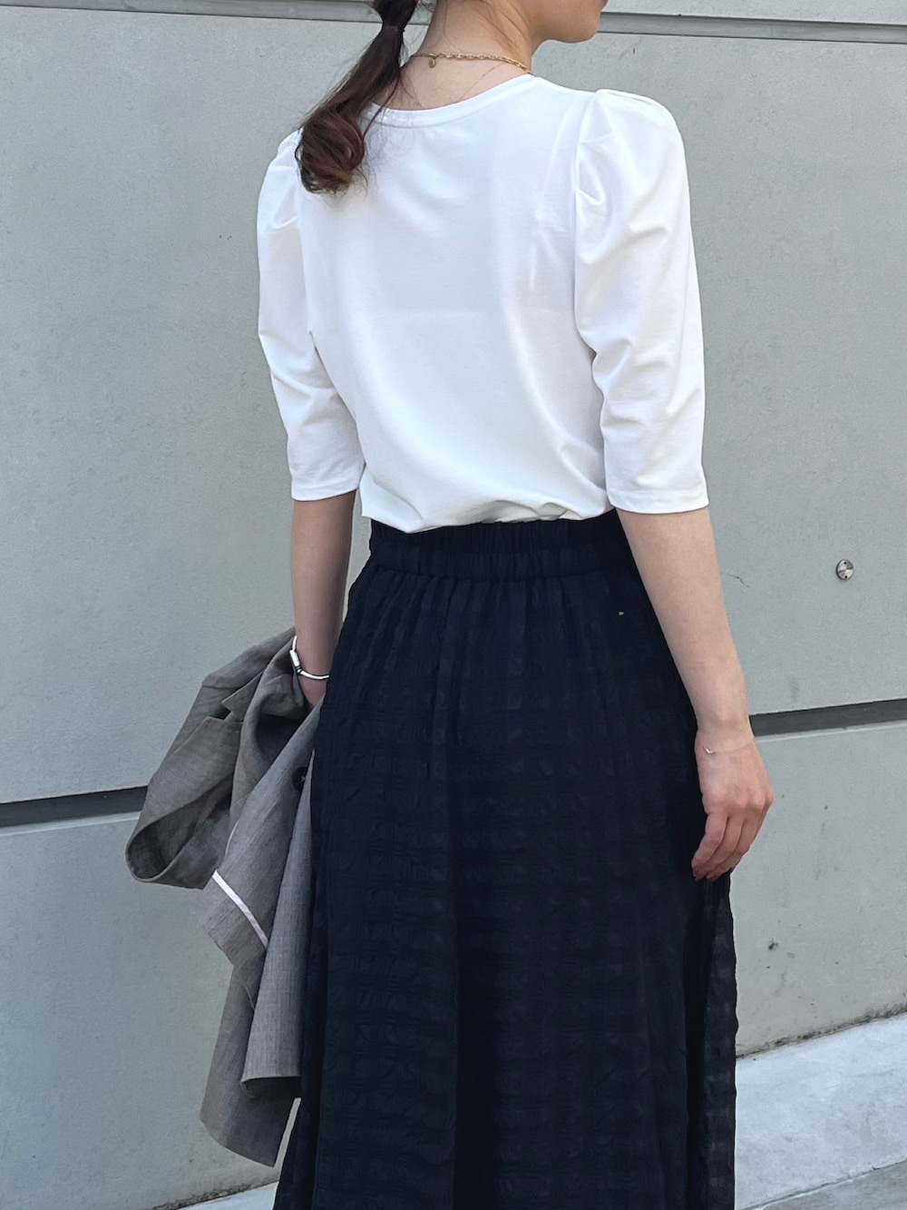 ホワイト系のTシャツ/カットソー、ブラック系のスカート、ブラウン系のテーラードジャケットを着用したレディースの夏コーディネートの4枚目の写真