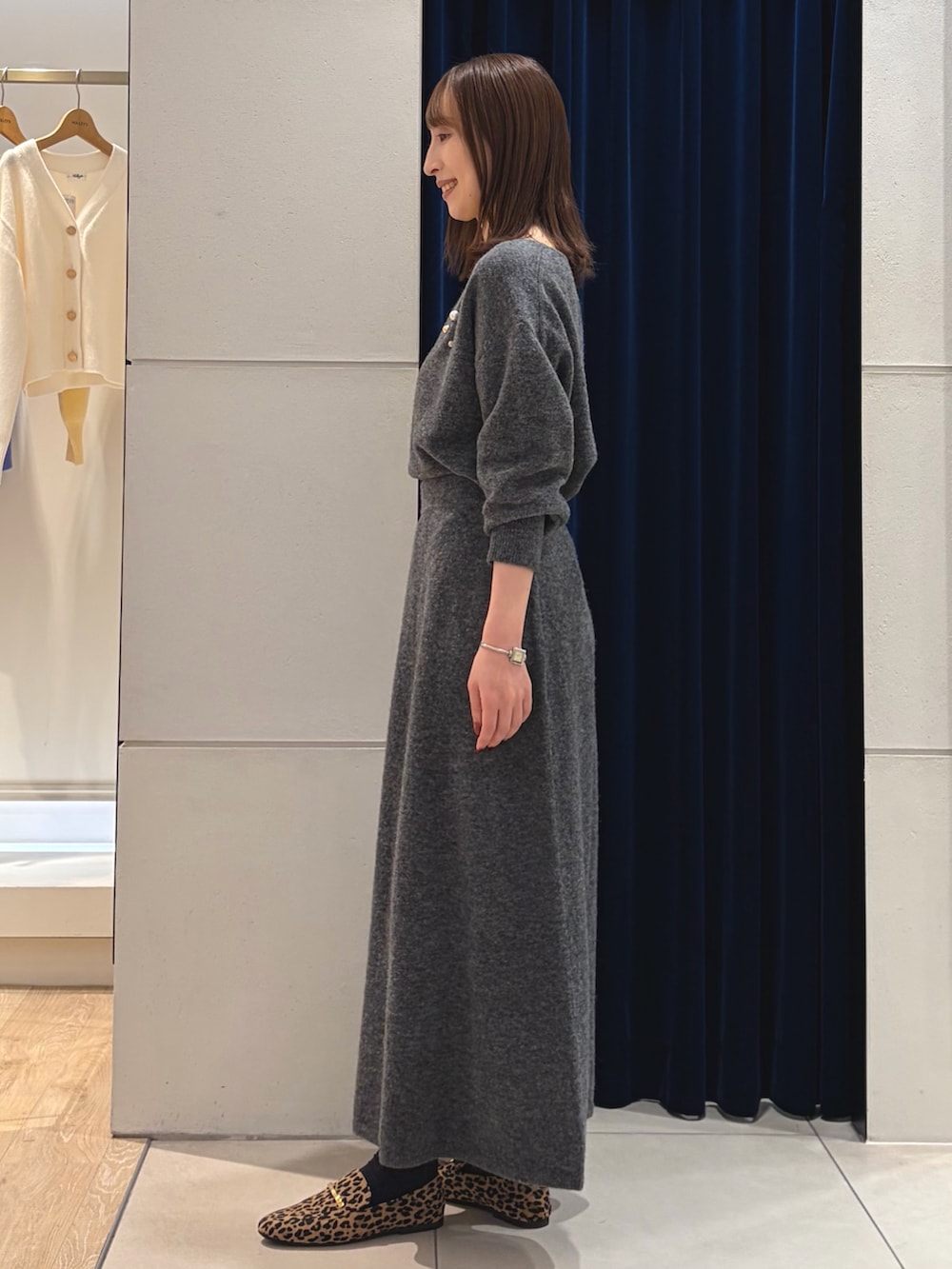 グレー系のニット/セーター、グレー系のスカート、ブラック系のショルダーバッグを着用したレディースの冬コーディネートの8枚目の写真