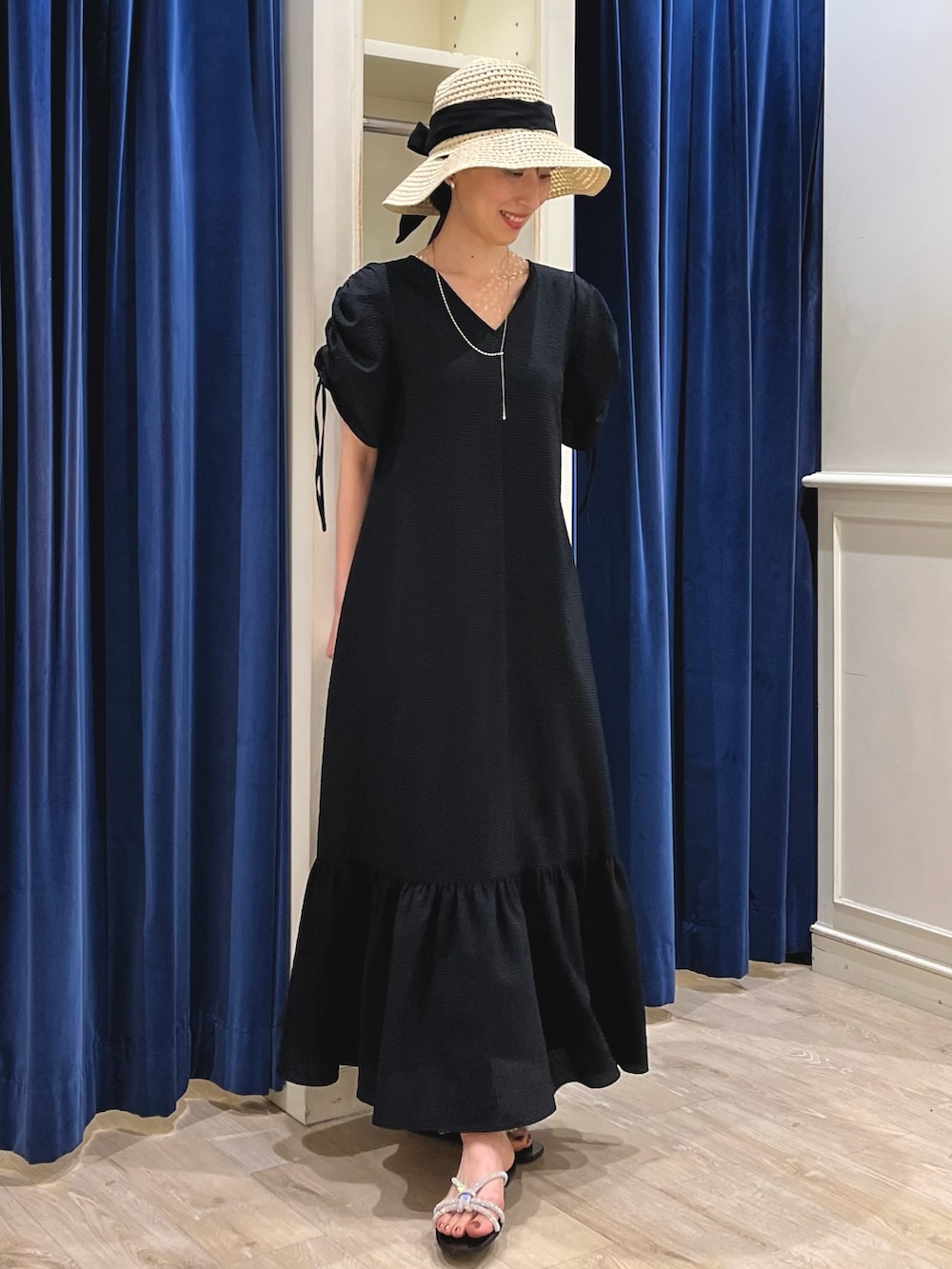 シルバー系のサンダル、ブラック系のワンピース、ベージュ系のハットを着用したレディースの春コーディネートの8枚目の写真