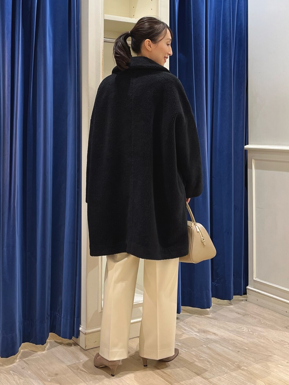 ブラック系のダッフルコート、ホワイト系のニット/セーター、イエロー系のその他パンツを着用したレディースの冬コーディネートの8枚目の写真