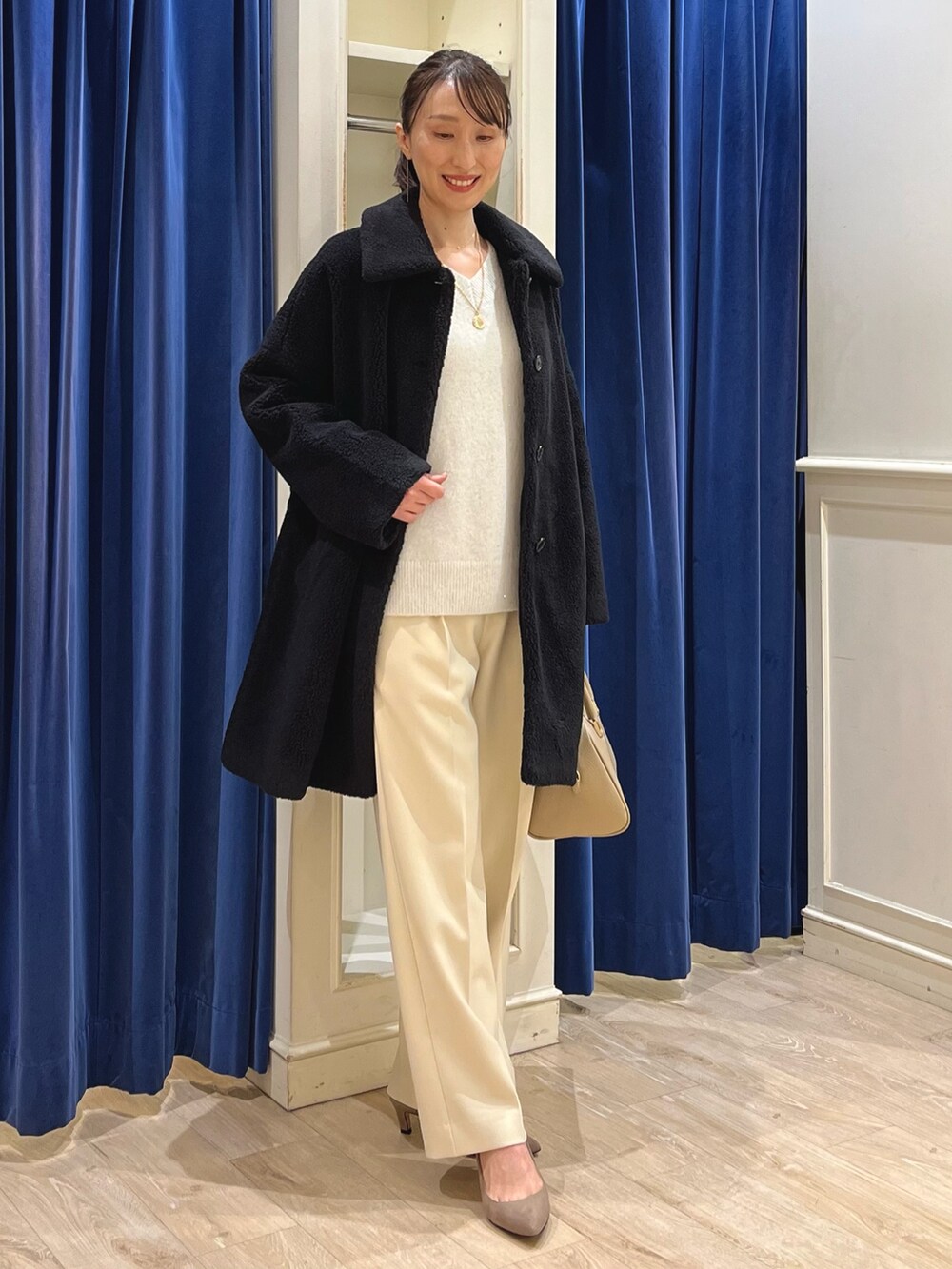 ブラック系のダッフルコート、ホワイト系のニット/セーター、イエロー系のその他パンツを着用したレディースの冬コーディネートの10枚目の写真