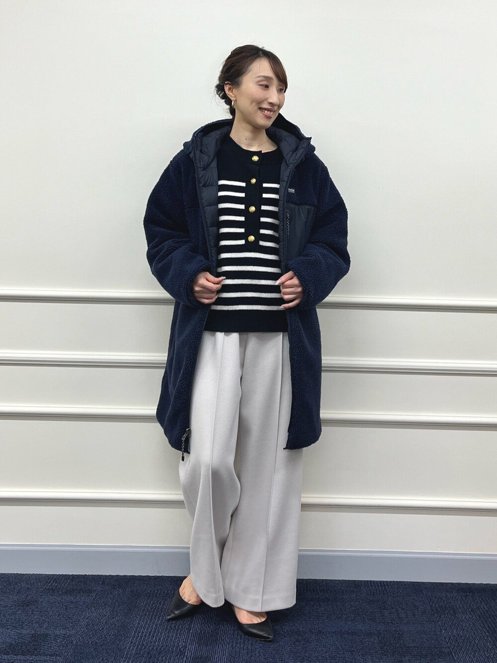 ブルー系のダウンジャケット/コート、ブラック系のニット/セーター、ベージュ系のその他パンツを着用したレディースの秋コーディネートの10枚目の写真