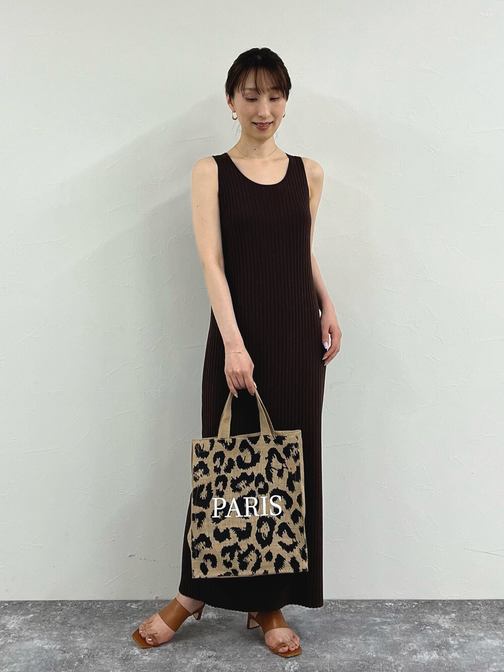 ブラウン系のワンピース、その他のトートバッグ、イエロー系のサンダルを着用したレディースの夏コーディネートの3枚目の写真