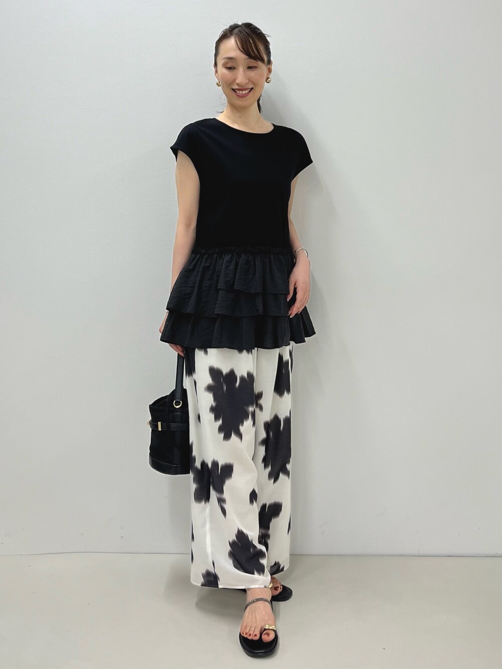 ブラック系のサンダル、ブラック系のTシャツ/カットソー、ホワイト系のその他パンツを着用したレディースの夏コーディネートの3枚目の写真