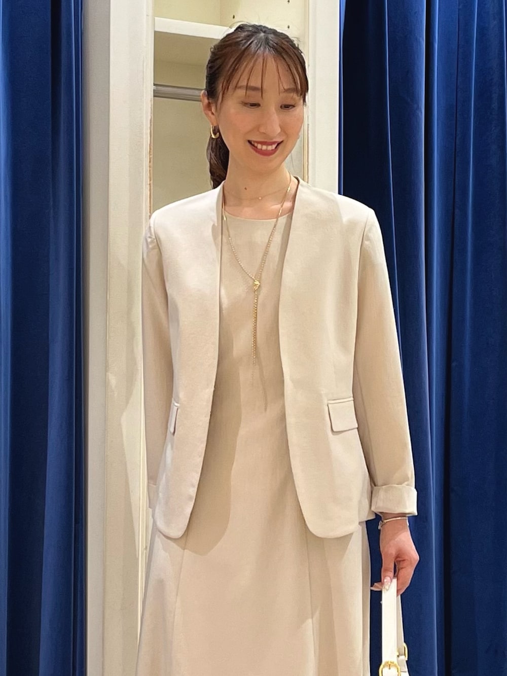 ベージュ系のノーカラージャケット、ホワイト系のショルダーバッグ、ゴールド系のサンダルを着用したレディースの夏コーディネートの4枚目の写真