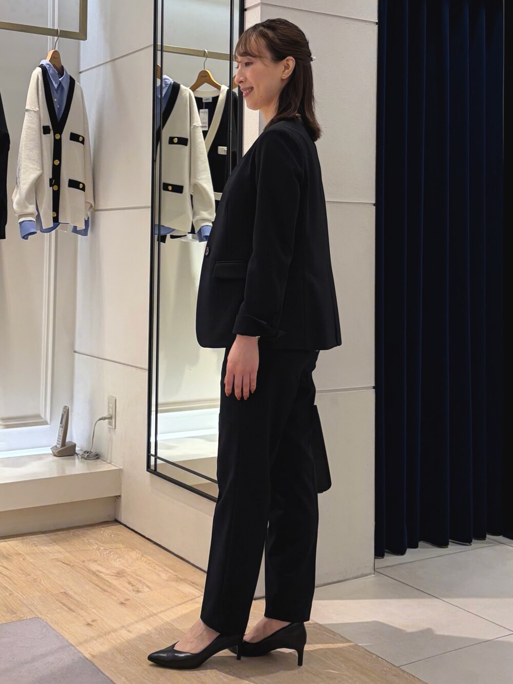 ホワイト系のシャツ/ブラウス、ブルー系のノーカラージャケット、ブラック系のショルダーバッグを着用したレディースの冬コーディネートの7枚目の写真