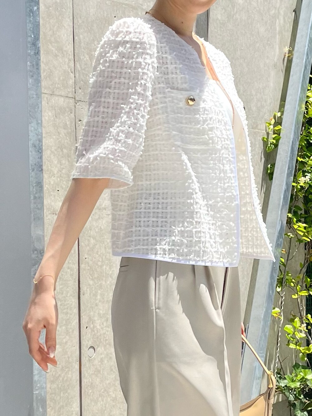 ホワイト系のノーカラージャケット、ベージュ系のその他パンツ、ベージュ系のショルダーバッグを着用したレディースの夏コーディネートの4枚目の写真