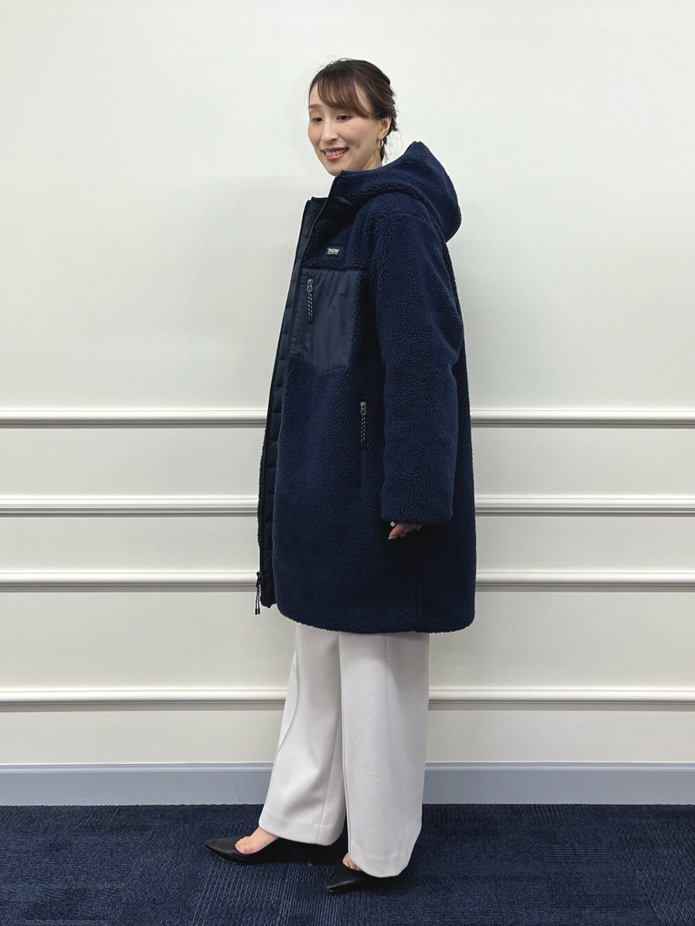 ブルー系のダウンジャケット/コート、ブラック系のニット/セーター、ベージュ系のその他パンツを着用したレディースの秋コーディネートの8枚目の写真