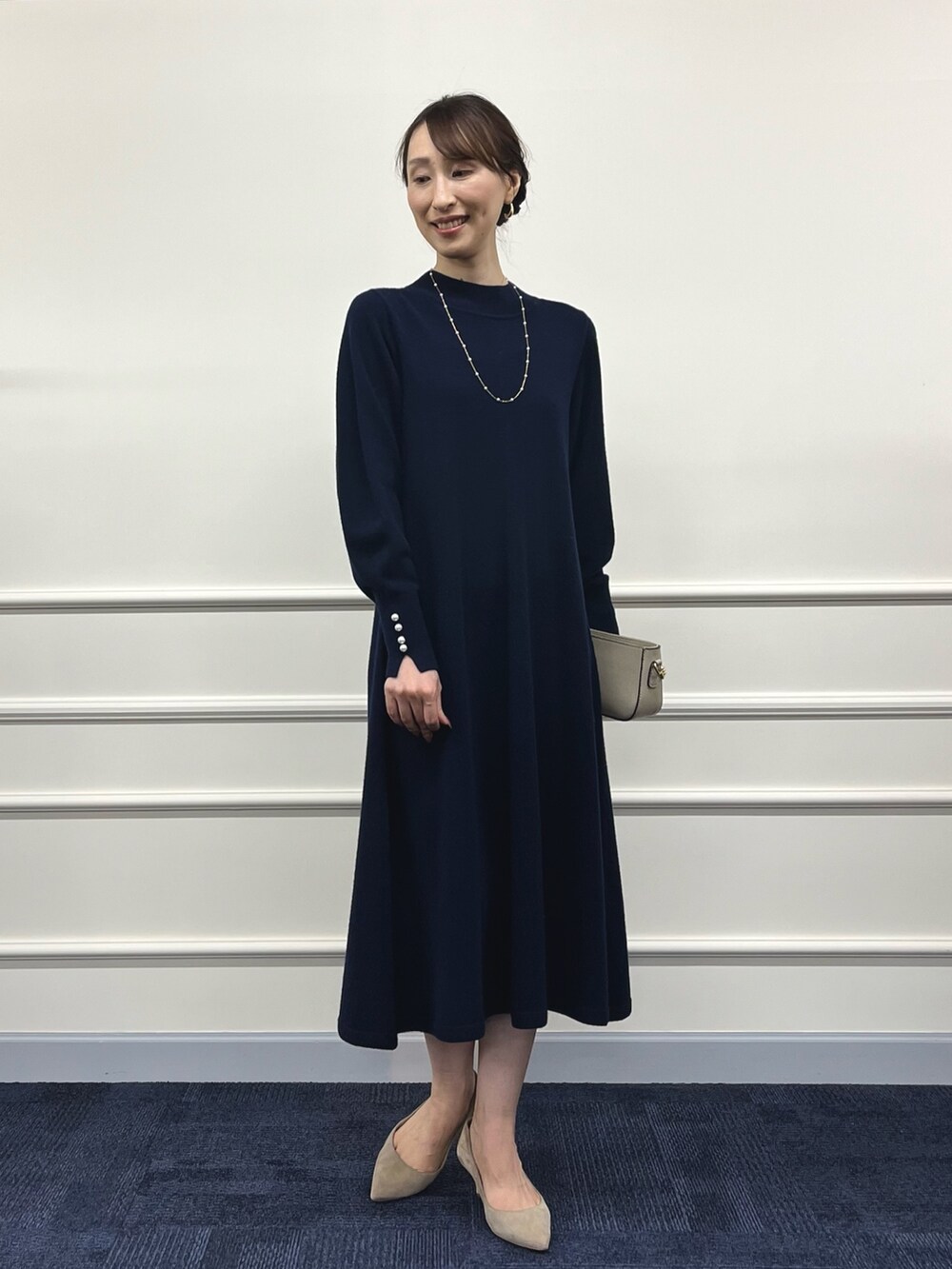 ベージュ系のショルダーバッグ、ブルー系のワンピース、ゴールド系のネックレスを着用したレディースの冬コーディネートの4枚目の写真