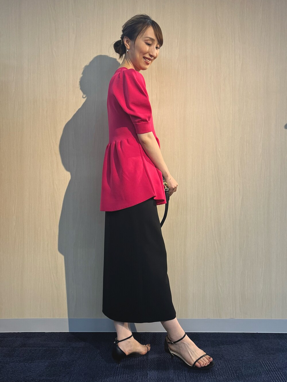 ピンク系のニット/セーター、ブラック系のショルダーバッグ、ブラック系のスカートを着用したレディースの夏コーディネートの5枚目の写真