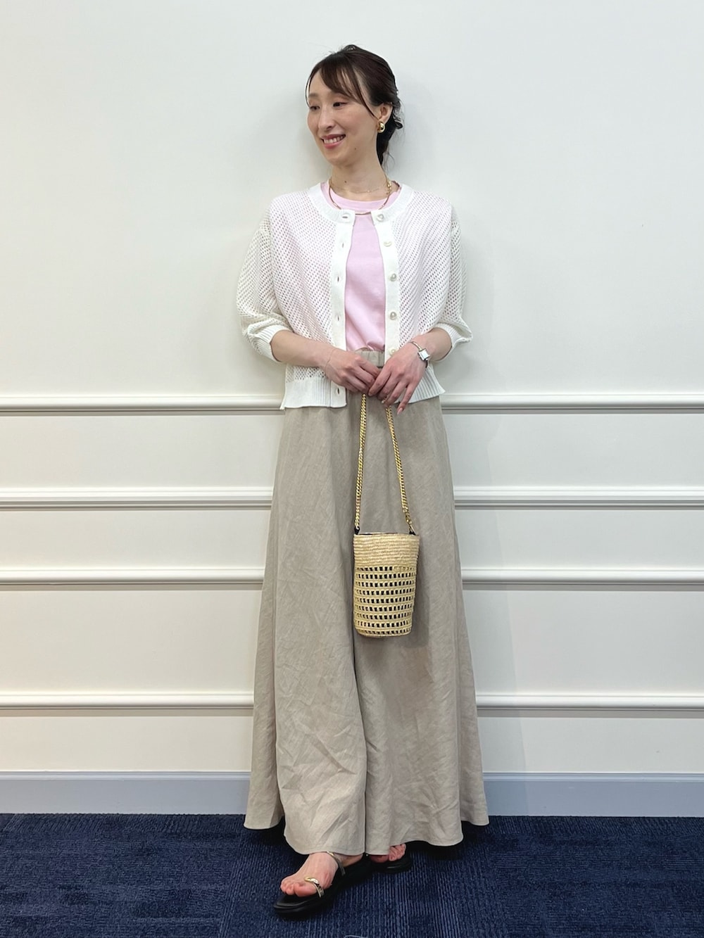 ホワイト系のカーディガン/ボレロ、ピンク系のTシャツ/カットソー、ベージュ系のスカートを着用したレディースの夏コーディネートの3枚目の写真